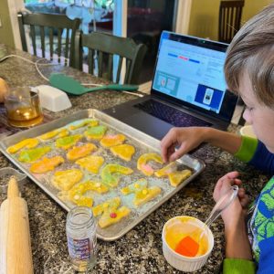 A boy making cookies as he participates in a virtual cooking class.